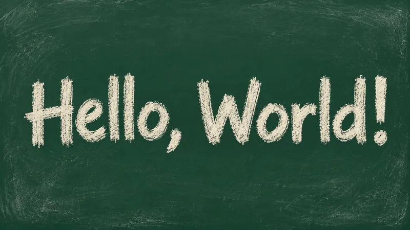 Hello, World! in grainy white chalk lettering on a dark green chalkboard